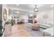 Bright, open-concept living room featuring hardwood floors and neutral decor, seamlessly flowing into the dining and kitchen areas at 4405 Gardenia St, Golden, CO 80403