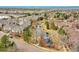 An aerial view showcases townhomes surrounding a pond, walking paths, and a community landscape at 9085 E Phillips Dr, Centennial, CO 80112