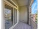 Balcony featuring stone columns, a sliding glass door, and wood-look flooring for outdoor enjoyment at 9085 E Phillips Dr, Centennial, CO 80112