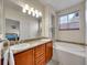 Bright bathroom featuring double sinks with granite countertops and a soaking tub beneath a window at 9085 E Phillips Dr, Centennial, CO 80112