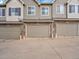 Townhome exteriors with stone accents, neutral siding, multi-car garages, and uniform design elements at 9085 E Phillips Dr, Centennial, CO 80112