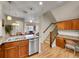 Open kitchen view with stainless appliances, granite counters, dining area, and staircase access at 9085 E Phillips Dr, Centennial, CO 80112