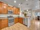 Well-lit kitchen featuring stainless steel appliances, light wood cabinets, and a view of the dining area at 9085 E Phillips Dr, Centennial, CO 80112