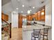 Modern kitchen with wood cabinets, stainless steel appliances, granite countertops, and breakfast bar seating at 9085 E Phillips Dr, Centennial, CO 80112