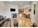 Spacious living area with a fireplace, wood floors, and an open layout to the kitchen at 9085 E Phillips Dr, Centennial, CO 80112