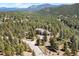 Scenic aerial view of home nestled in a lush forest, surrounded by towering trees and mountain views at 6252 King Dr, Evergreen, CO 80439