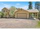Charming home exterior featuring an attached garage with carport and well-maintained yard at 6252 King Dr, Evergreen, CO 80439