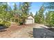 Single-car garage surrounded by tall evergreen trees, offering privacy and seclusion at 6252 King Dr, Evergreen, CO 80439