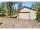 Exterior view of a single car garage nestled among trees in a backyard at 6252 King Dr, Evergreen, CO 80439