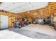 Bright garage interior featuring exposed wood framework, ample shelving, and included ATV at 6252 King Dr, Evergreen, CO 80439