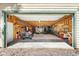 Bright garage interior featuring exposed wood framework, ample shelving, and included ATV at 6252 King Dr, Evergreen, CO 80439