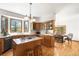 A spacious kitchen with wood cabinets, an island cooktop, and a sunny dining area at 6252 King Dr, Evergreen, CO 80439