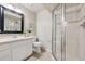 Bright bathroom with a glass-enclosed shower, white vanity, and neutral tiling at 1913 Julian St, Denver, CO 80204
