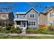 Attractive two-story home with a well-kept lawn, complemented by mature trees and manicured shrubs at 1913 Julian St, Denver, CO 80204