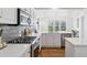 Gourmet kitchen featuring quartz countertops, a subway tile backsplash, and stainless-steel appliances and a large window at 1913 Julian St, Denver, CO 80204