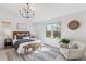 Bright main bedroom with a vaulted ceiling, stylish chandelier, large window, and comfortable seating at 1913 Julian St, Denver, CO 80204