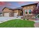 Charming home with a stone facade, manicured lawn, and a welcoming entrance at 15506 Short Line Ct, Monument, CO 80132