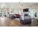 Spacious living room featuring wood floors, a stone fireplace, a leather couch, and an abundance of natural light at 15506 Short Line Ct, Monument, CO 80132