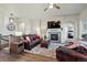 Cozy living room features a stone fireplace, modern lighting, and comfortable leather seating at 15506 Short Line Ct, Monument, CO 80132