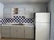 Kitchen with gray cabinets and a checkerboard backsplash at 8551 Circle Dr, Westminster, CO 80031