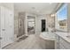 Bright bathroom features dual vanities, soaking tub, a glass shower and modern tile at 9532 Palmer Lake Ave, Littleton, CO 80125