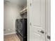 Modern laundry room with side-by-side washer and dryer, tile floor, and shelving at 9532 Palmer Lake Ave, Littleton, CO 80125