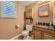 Charming half bathroom with tiled floors, granite countertop, and ample cabinet space at 4593 S Field St, Littleton, CO 80123