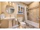 Well-lit bathroom features a pedestal sink, neutral tile, and built-in shelving for optimal storage and style at 4593 S Field St, Littleton, CO 80123