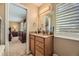 Bright bathroom with wood cabinets, granite counters, and an adjacent bedroom at 4593 S Field St, Littleton, CO 80123