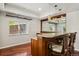 Basement bar featuring wood floors, granite countertop and wood bar stools at 2485 Vale Way, Erie, CO 80516