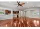 Open-concept living room with hardwood floors, ceiling fan, and access to the kitchen at 2485 Vale Way, Erie, CO 80516