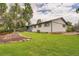 Expansive backyard with manicured lawn, mature trees, landscaping, and a covered patio perfect for entertaining at 1819 S Nile Ct, Aurora, CO 80012