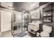 Modern bathroom featuring tiled shower with glass enclosure, industrial shelving, vanity, and toilet at 1819 S Nile Ct, Aurora, CO 80012
