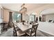 Bright dining room with contemporary lighting, neutral decor, and arched openings to adjacent rooms at 1819 S Nile Ct, Aurora, CO 80012