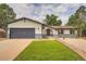 Charming home featuring a well-maintained lawn, complemented by tasteful rock landscaping and a painted two-car garage door at 1819 S Nile Ct, Aurora, CO 80012