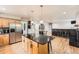 Spacious kitchen featuring stainless steel appliances, hardwood floors, and a center island with modern lighting at 1819 S Nile Ct, Aurora, CO 80012