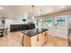 Bright kitchen featuring an island with dark countertops, ample cabinets, and an entertainment area at 1819 S Nile Ct, Aurora, CO 80012