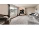 Cozy living room featuring plush carpeting, a large window with curtains, and comfortable couches at 1819 S Nile Ct, Aurora, CO 80012