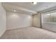 An open basement features neutral carpet, a window for natural light, and recessed lighting at 8107 S Catawba Ct, Aurora, CO 80016