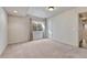 Carpeted basement features neutral walls and carpet, a window and a utility door at 8107 S Catawba Ct, Aurora, CO 80016