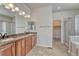 Modern bathroom with double sinks, granite countertops, walk-in shower, and a view of a walk-in closet at 8107 S Catawba Ct, Aurora, CO 80016