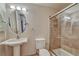 Bathroom featuring a pedestal sink, toilet, and glass enclosed shower with bronze fixtures at 8107 S Catawba Ct, Aurora, CO 80016