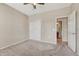 Spacious bedroom with gray carpet, a ceiling fan, a closet with white doors, and an open entrance to the bathroom at 8107 S Catawba Ct, Aurora, CO 80016