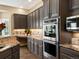 This kitchen features stainless appliances, a double oven, and dark brown cabinets at 6266 W Prentice Ave, Littleton, CO 80123