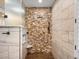 Stylish shower features stone wall accents, a rainfall shower head, and built-in shelving at 6266 W Prentice Ave, Littleton, CO 80123
