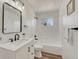 Clean bathroom featuring black hardware, wood floors, a bathtub, and a bright window at 20011 E Bellewood Dr, Centennial, CO 80015