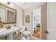 Bathroom with a pedestal sink, decorative mirror, and neutral color scheme at 6839 S Niagara Ct, Centennial, CO 80112