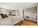 Bright bedroom featuring hardwood floors, modern decor, a ceiling fan, and a view into the ensuite bathroom at 6839 S Niagara Ct, Centennial, CO 80112
