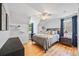 Comfortable bedroom featuring hardwood floors, a ceiling fan, and plenty of natural light from two windows at 6839 S Niagara Ct, Centennial, CO 80112