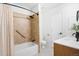 Bright bathroom featuring a shower with a tub, a single sink vanity, and tiled walls and floors at 6318 Newton Ct, Arvada, CO 80003